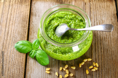 Homemade pesto sauce. Ingredients. Cheese, garlic, basil, pine nuts, olive oil on an old wooden table. photo