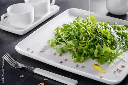 Eruca vesicaria fresh green lettuce dietary on white beautiful tableware.