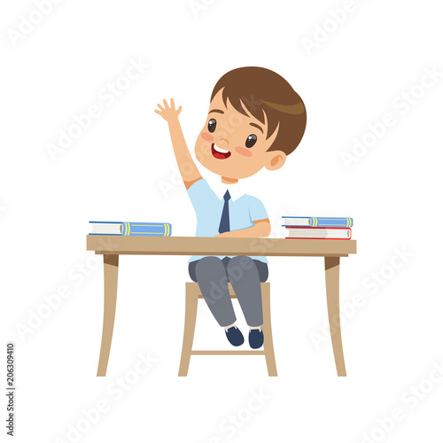 Cute boy sitting at the desk and rising his hand, elementary school student in uniform vector Illustration on a white background