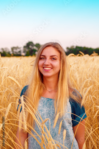 Young girl is in the field wheat  in ripe ears.