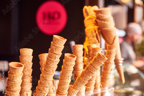 A pile of wafer cups for ice cream in a cafe, restaurant. Procurement for a sweet summer treat. Edible glass of crispy thin waffle. Showcase of a cafe, a pastry shop, a restaurant