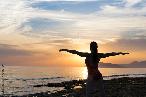 Silhouette healthy woman doing Yoga exercises on the beach in sunset time, Thailand © Stavros