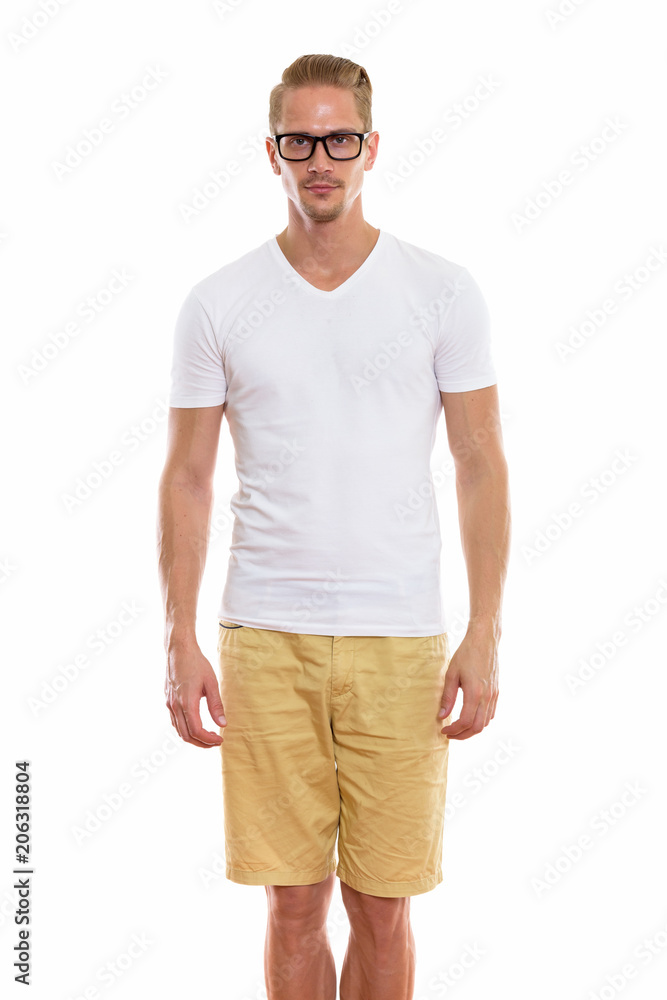 Studio shot of young handsome man standing while wearing eyeglas Studio shot of young handsome man standing while wearing eyeglas