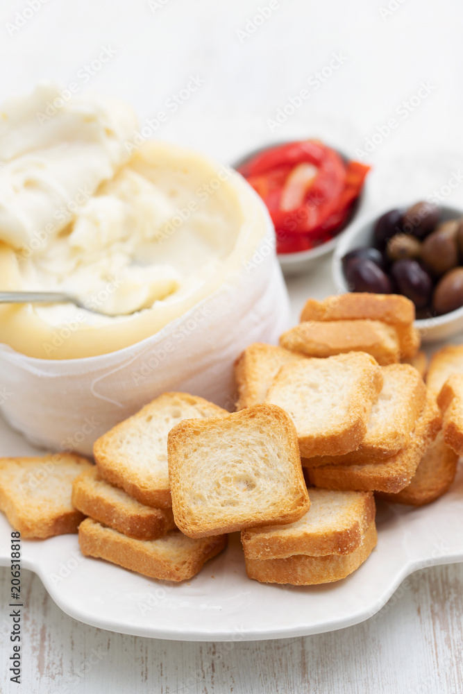toasts with cheese, olives and red pepper on white dish toasts with cheese, olives and red pepper on white dish
