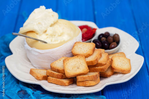 toasts with cheese, olives and red pepper on white dish