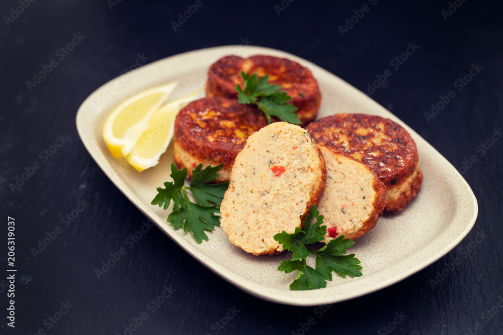 fish balls with lemon on dish on black ceramic background fish balls with lemon on dish on black ceramic background