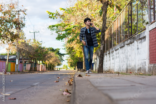 Man walking on the sidewalk talking on the mobile phone. photo