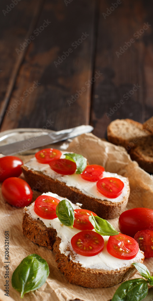 Bruschetta with cream cheese, cherry tomatoes and basil