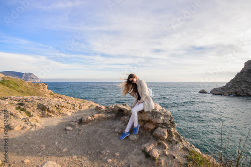 Beautiful girl outdoors. Spring day. The girl with long hair photographes itself near the sea