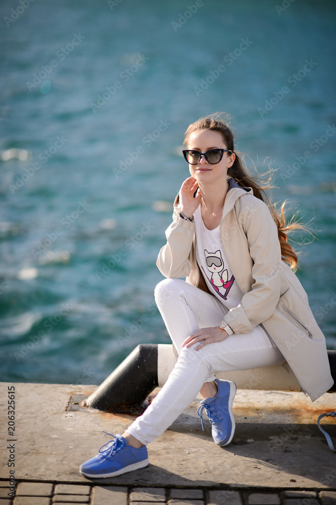 Beautiful girl outdoors. Spring day. The girl with long hair near the sea Beautiful girl outdoors. Spring day. The girl with long hair near the sea
