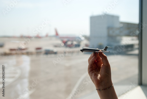 Milan, Italy - April 23, 2018: toy plane held in the background with the Milan Malpensa airport square photo