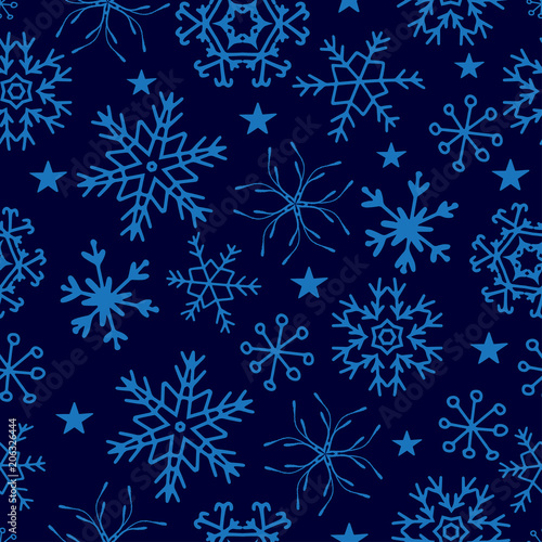 Seamless pattern from snowflakes on deep blue background