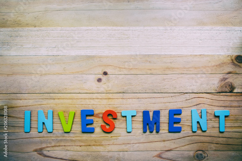 INVESTMENT wooden word on w...