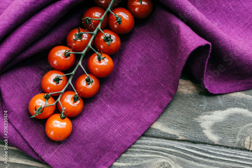 Tableau sur toile Cherry tomatoes branch on purple napkin