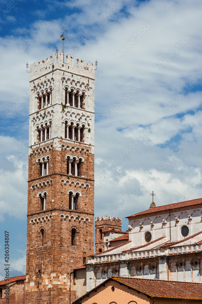 Lucca Cathedral medieval bell tower, erected in the 13th century, among clouds