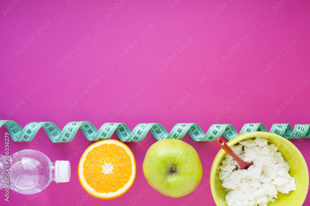Fruits, curd, measuring tape, water and muesli on the pink background