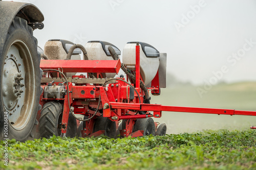 Farmer seeding, sowing crops at field. Sowing is the process of planting seeds in the ground as part of the early spring time agricultural activities.