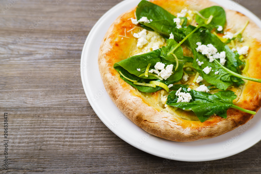 Italian appetizer, snack, banquet, family restaurant menu concept. Delicious focaccia with cottage cheese ans spinach leaves on restaurant table Italian appetizer, snack, banquet, family restaurant menu concept. Delicious focaccia with cottage cheese ans spinach leaves on restaurant table