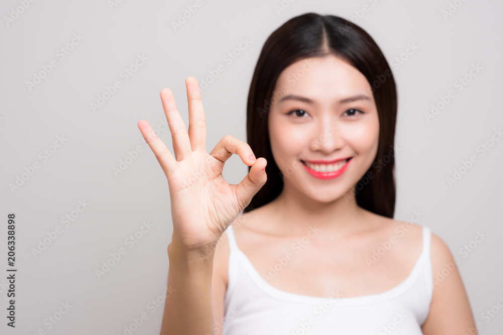 Portrait of a beautiful young woman with clean skin gesture ok sign. Portrait of a beautiful young woman with clean skin gesture ok sign.