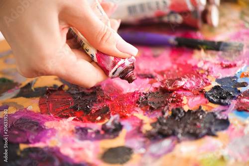 art, creativity and people concept - close up of artist with palette knife painting still life on easel at studio