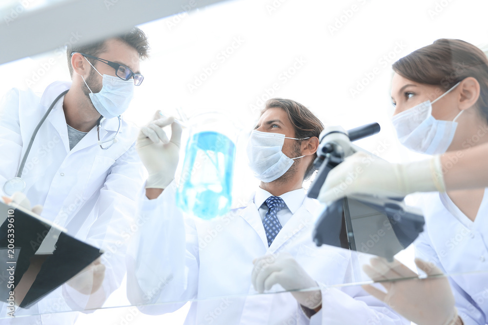 young scientists working with a microscope and test tubes young scientists working with a microscope and test tubes