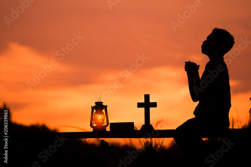 silhouette Boy praying to god with oil lamp, christian concept