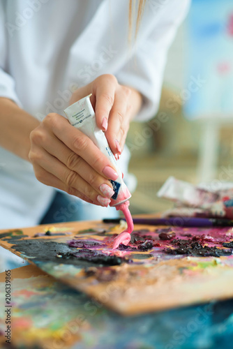 art, creativity and people concept - close up of artist with palette knife painting still life on easel at studio