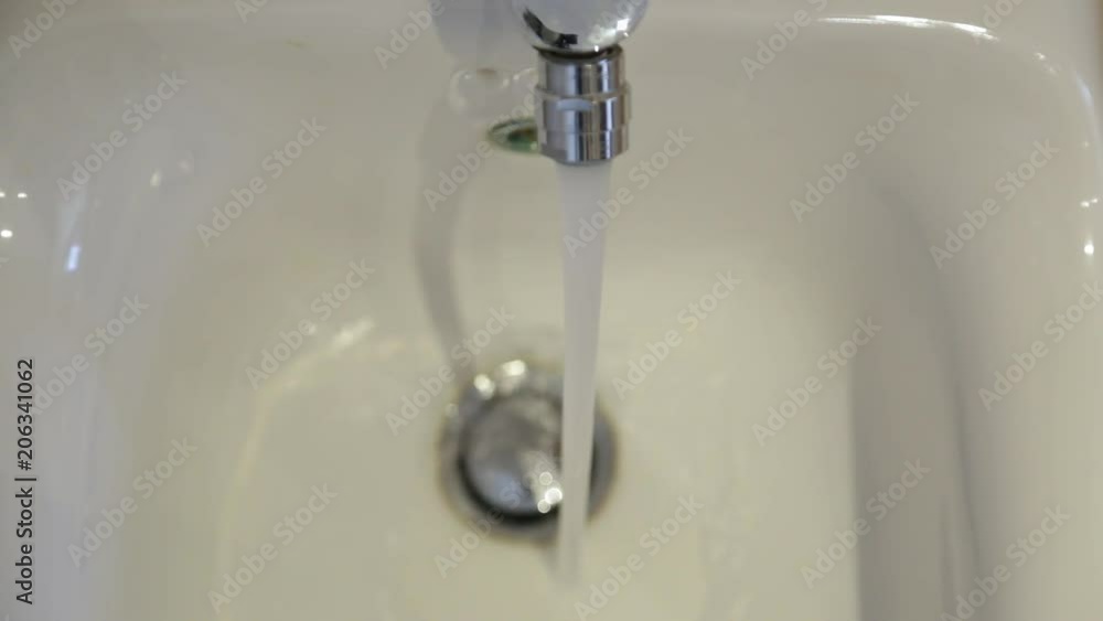 Closeup top view of white ceramic bidet in bathroom. Warm water pouring from tap. Closeup top view of white ceramic bidet in bathroom. Warm water pouring from tap.