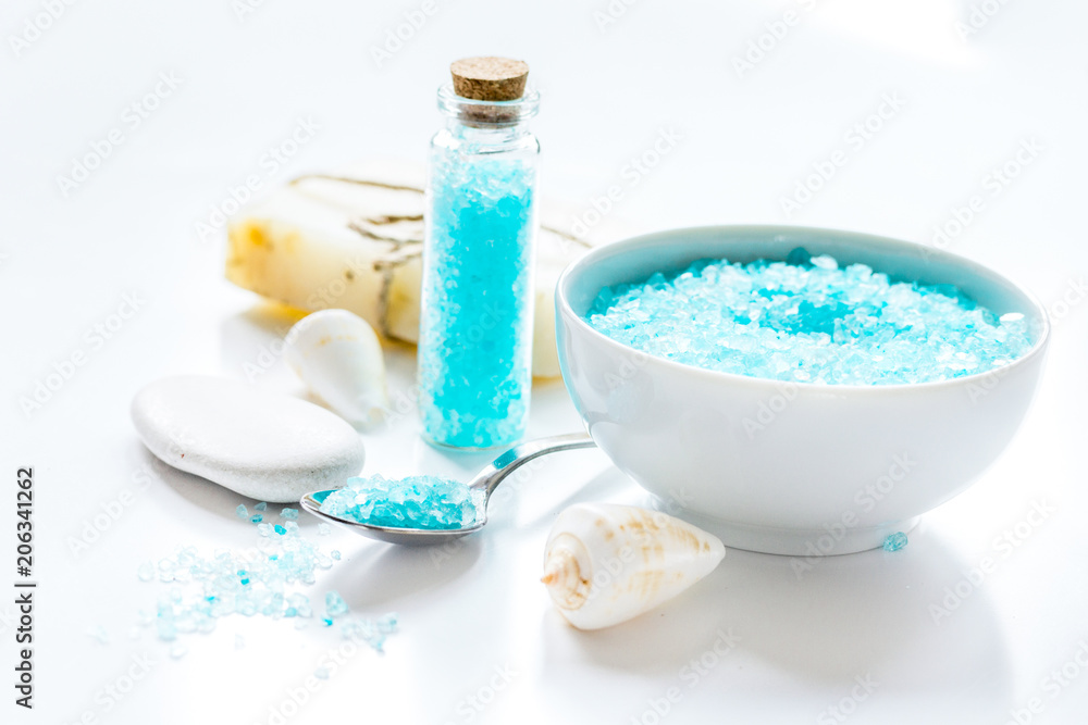 blue bath salt, body cream and shells for spa on white table bac blue bath salt, body cream and shells for spa on white table bac
