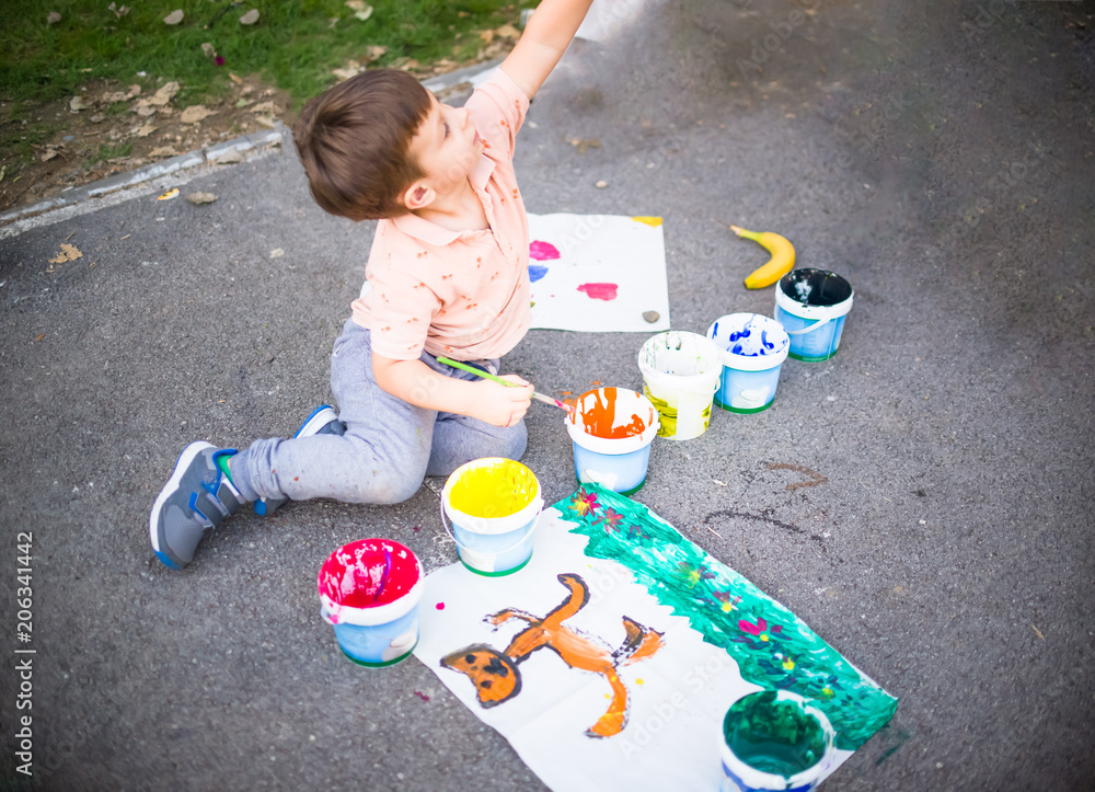 Naklejka premium Portrait of a little boy enjoying his painting