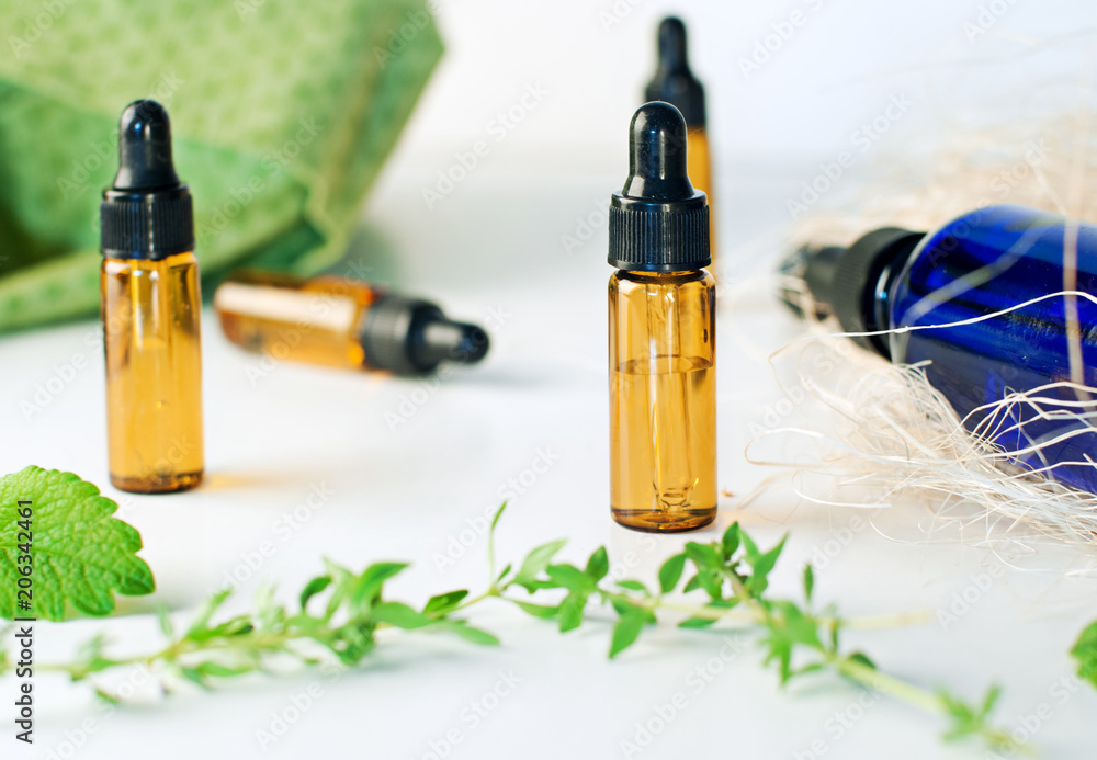 Brown and blue bottles of essential oil with fresh thyme