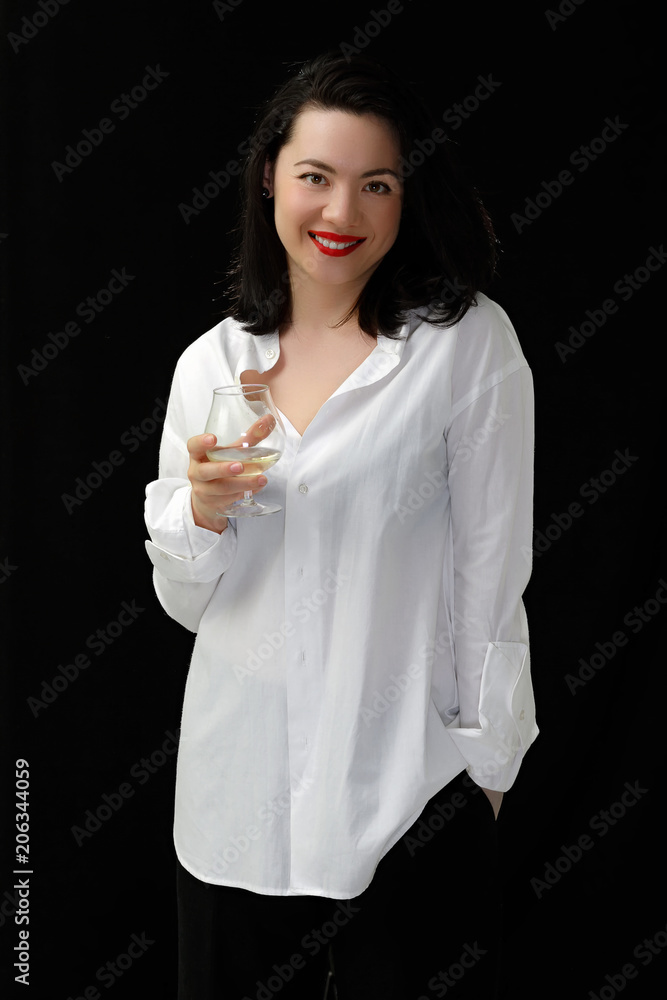 Portrait young brunette beauty holding glass of wine in white shirt on black background. Portrait young brunette beauty holding glass of wine in white shirt on black background.