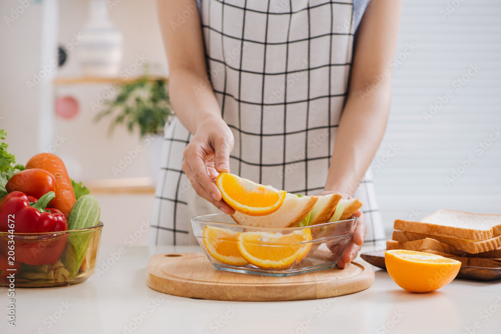 Hands of a woman is making school lunch box. It is more interesting for children. Hands of a woman is making school lunch box. It is more interesting for children.
