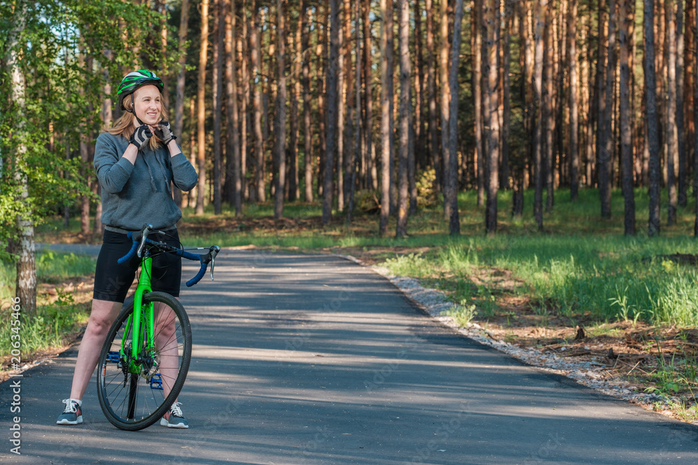 Fototapeta premium Girl on a bicycle in the park. A racing bicycle. Active way of life and playing sports.
