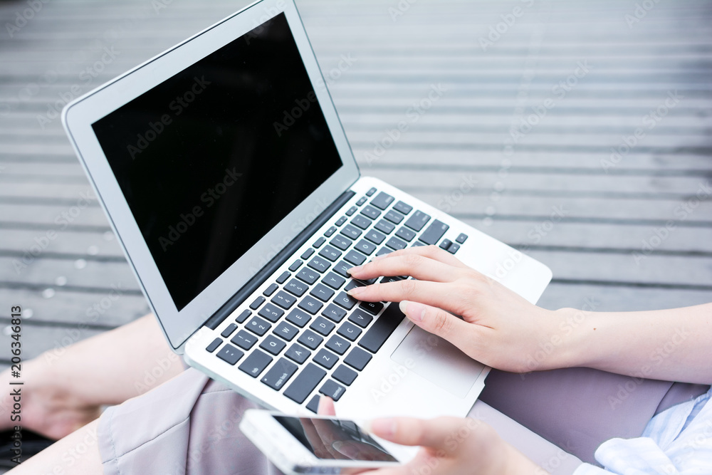 Female hands with mobile phone and laptop Female hands with mobile phone and laptop