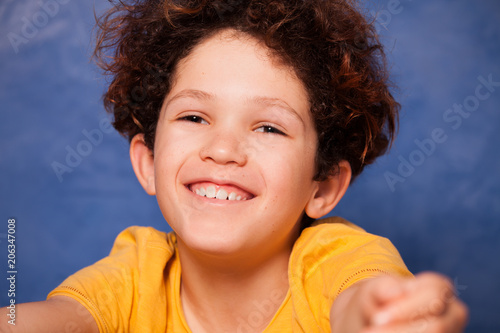 Fotografija Happy curly boy smiling and looking at camera