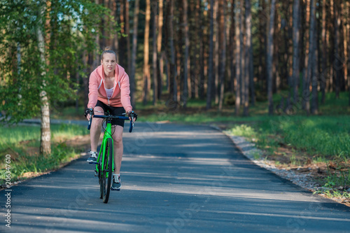 Wallpaper Mural Girl on a bicycle in a pink hoodie in the park. Races on a bicycle. Active way of life and playing sports. Torontodigital.ca