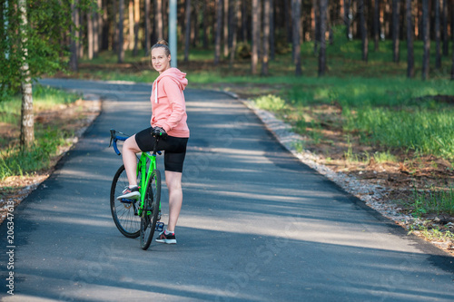 Wallpaper Mural Girl on a bicycle in a pink hoodie in the park. Races on a bicycle. Active way of life and playing sports. Torontodigital.ca