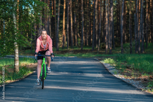 Wallpaper Mural Girl on a bicycle in a pink hoodie in the park. Races on a bicycle. Active way of life and playing sports. Torontodigital.ca