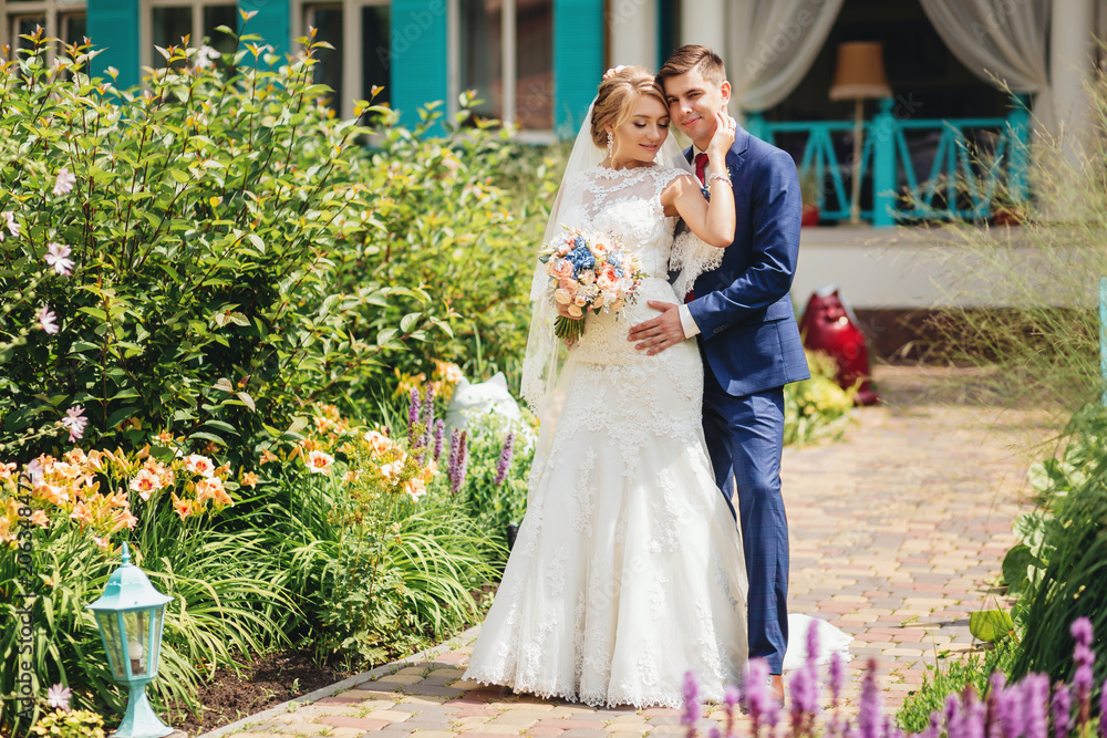 Beautiful stylish bride and groom on the walk in park on their wedding day Beautiful stylish bride and groom on the walk in park on their wedding day