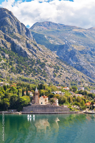 Montenegro. Dobrota town. Beautiful view of the church of St. Matthew (Crkva Sv. Matije, 1670) on the seafront of Boka Kotor Bay on a sunny day
