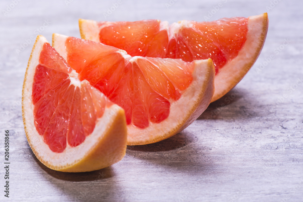 Grapefruit slices, juicy ripe isolated on a gray background Grapefruit slices, juicy ripe isolated on a gray background