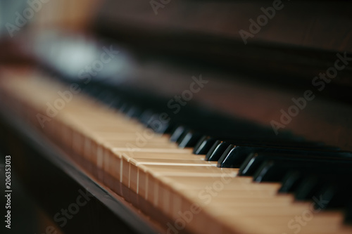 Keys of an old piano in blur. Musical ancient instrument with a wooden case. Vintage.