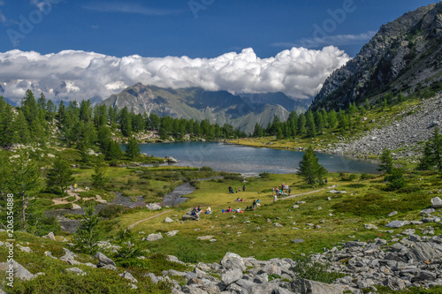 Arpy Lake, Valle d’Aosta, Italy. Alpine pond on Italian alps. Beautiful mountain panorama. Enjoying nature in summer day with blue cloudy sky. Landscape from Colle San Carlo, La Thuile, IT. 