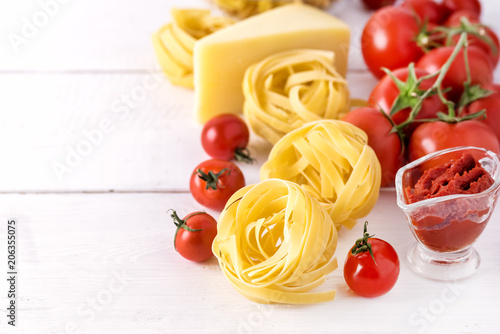 Pasta Products with Tomato Cheese Raw Pasta Fusili Fettuccine Ingredients Italian Food White Background Close Up Copy Space