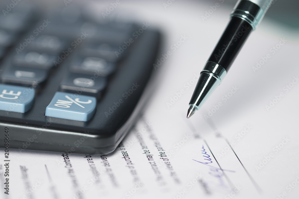 Financial money loan, mortgage or buy and sell contract with bank, printed paper form with pen to sign and calculator. Selected focus Financial money loan, mortgage or buy and sell contract with bank, printed paper form with pen to sign and calculator. Selected focus
