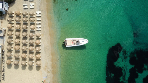 Aerial drone photo of luxury yacht docked in famous turquoise clear water beach of Psarou, island of Mykonos, Cyclades, Greece © aerial-drone