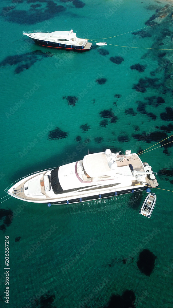 Aerial drone photo of luxury yacht docked in famous turquoise clear water beach of Psarou, island of Mykonos, Cyclades, Greece Aerial drone photo of luxury yacht docked in famous turquoise clear water beach of Psarou, island of Mykonos, Cyclades, Greece