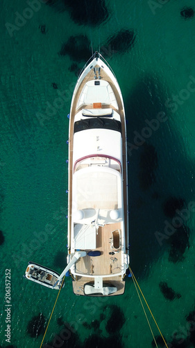 Aerial drone photo of luxury yacht docked in famous turquoise clear water beach of Psarou, island of Mykonos, Cyclades, Greece © aerial-drone