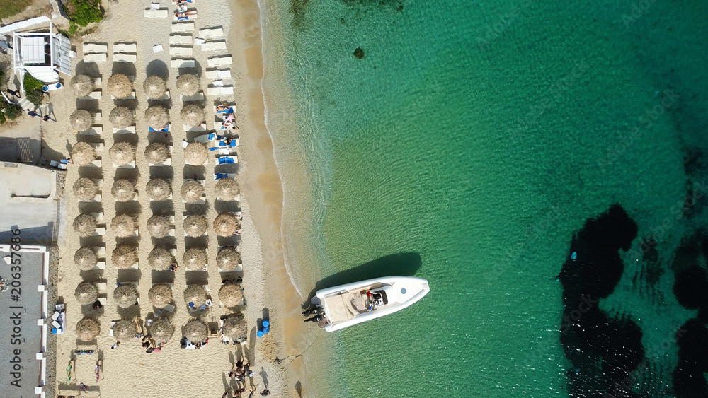 Aerial drone photo of luxury yacht docked in famous turquoise clear water beach of Psarou, island of Mykonos, Cyclades, Greece
